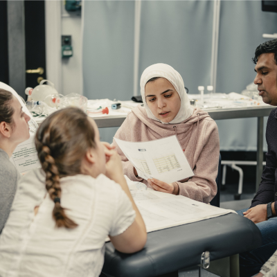 a group of people analysing a sheet of paper at IMPACT course